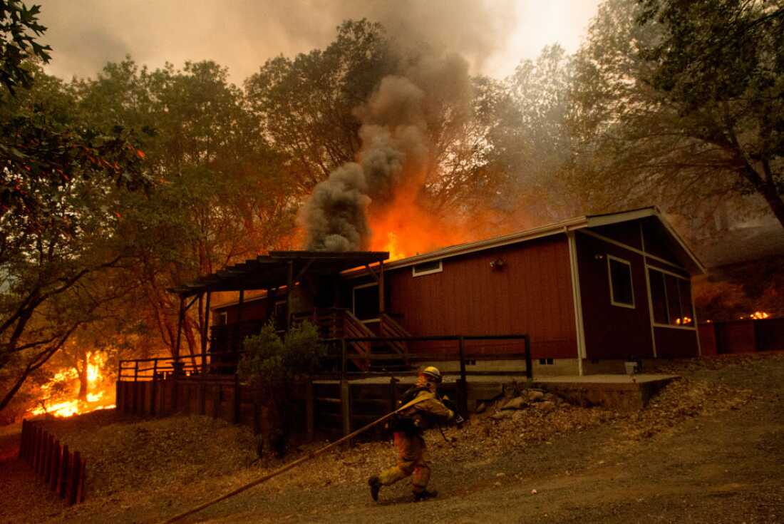 Firefighters attempt to save a burning house during the Valley fire in Seigler Springs, California on September 13, 2015.