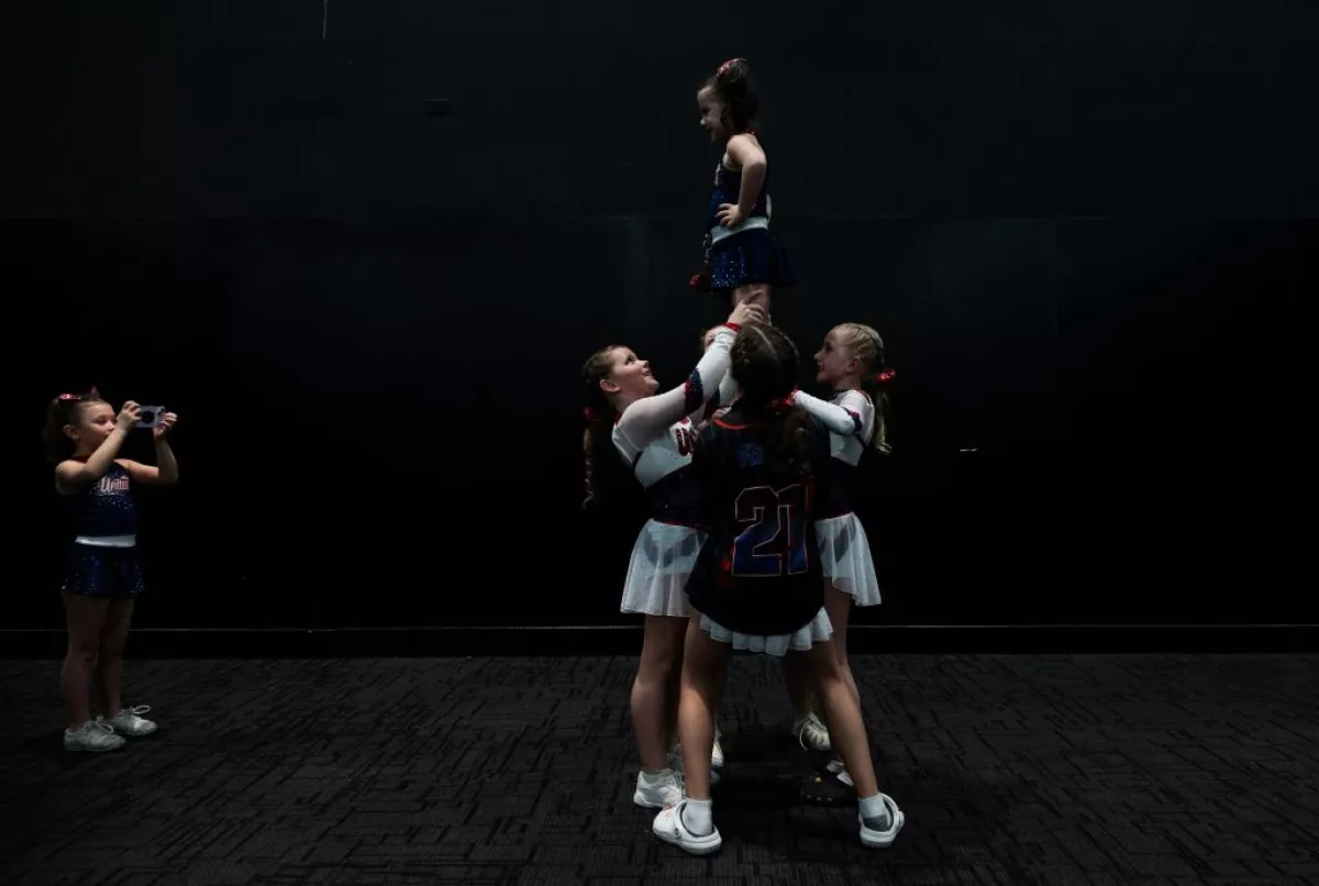 A young cheerleader takes a photo of her teammates practicing during the Frost Extreme cheerleading event in Wilmington, Delaware, on January 29, 2023. The majority of cheerleaders are girls aged 6-17.