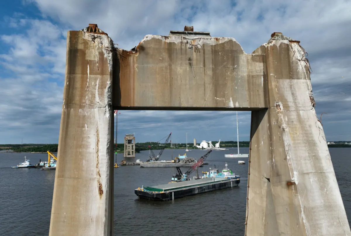 A construction barge moves past salvage crews as they continue to clean up the wreckage from the collapse of the Francis Scott Key Bridge in the Patapsco River on June 11 in Baltimore.