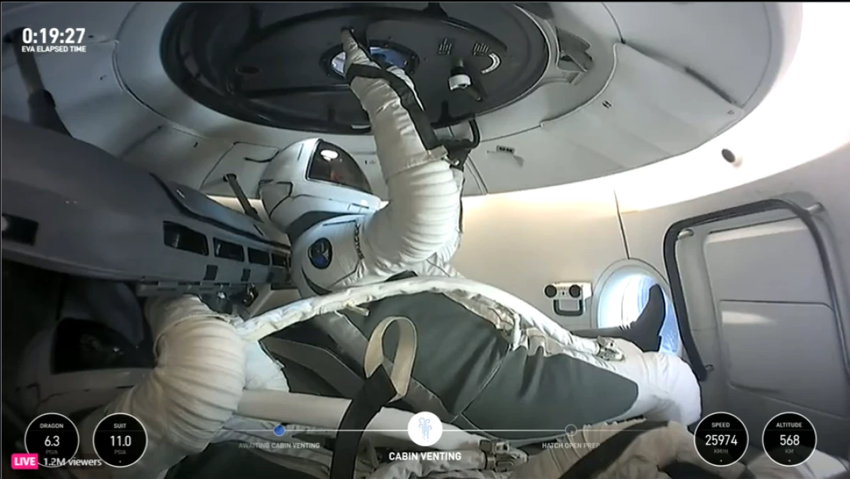 Jared Isaacman floats just below the hatch of his SpaceX dragon capsule while he awaits the first private spacewalk.