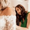 Claire Landgraf helps a bride try on a dress at her shop Finery Bridal Chic in Rochester, Minn.