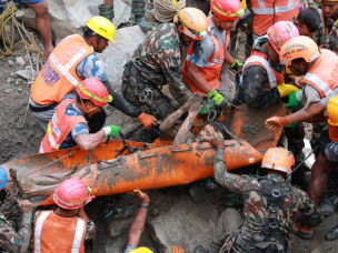 In this photo provided by the Nepal Army, soldiers rescue a worker alive from a tunnel during an ongoing operation at the Trishuli-3A hydropower project in Nepal's Rasuwa district, Friday.