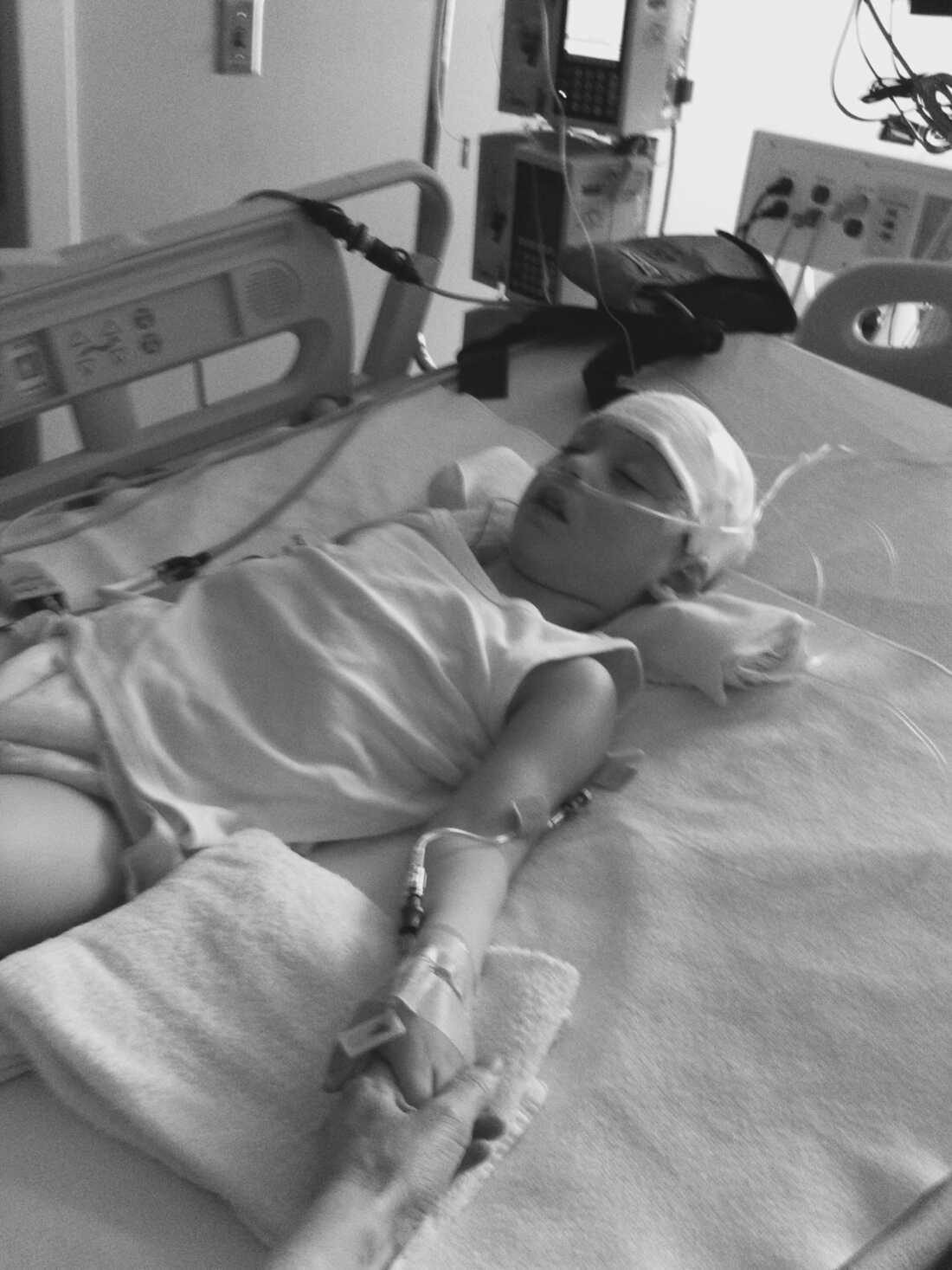 Ysadore Maklakoff, pictured during a stay at the hospital in 2011, is shown in a hospital bed sleeping or unconscious. His head is bandaged; he wears a breathing tube in his nose and has an IV in his arm.