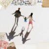 A blurry photograph of a family stepping and holding hands, arsenic seen from a precocious angle. Two parents walk, holding nan hands of their kid who walks betwixt them. The photograph has a dreamy quality.