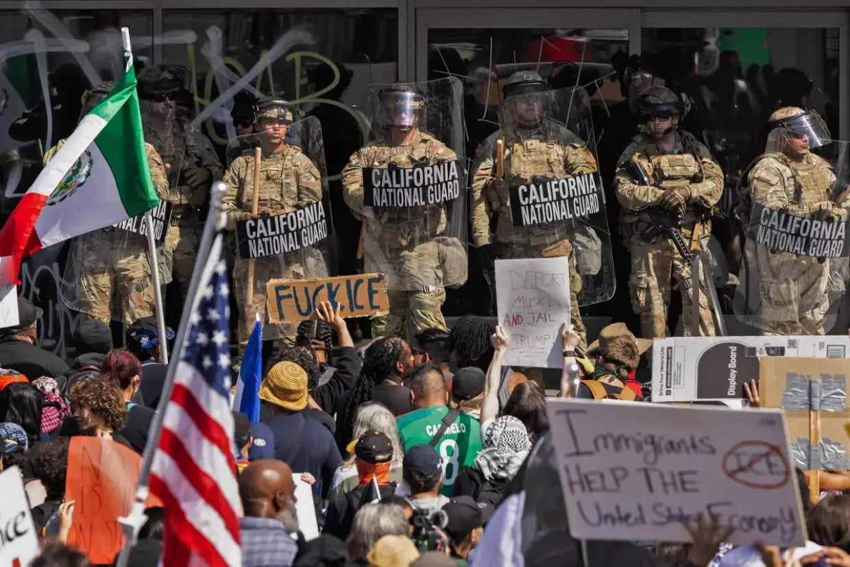 Demonstrators protest against recent ICE immigration raids as National Guard officers stand guard in front of a federal building in Los Angeles on June 9, 2025. Photo by Ted Soqui for CalMatters