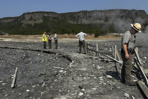 In this photo released by the National Park Service, park staff assess the damage to Biscuit Basin boardwalks after a hydrothermal explosion at Biscuit Basin in Yellowstone National Park, Wyo., on Tuesday.