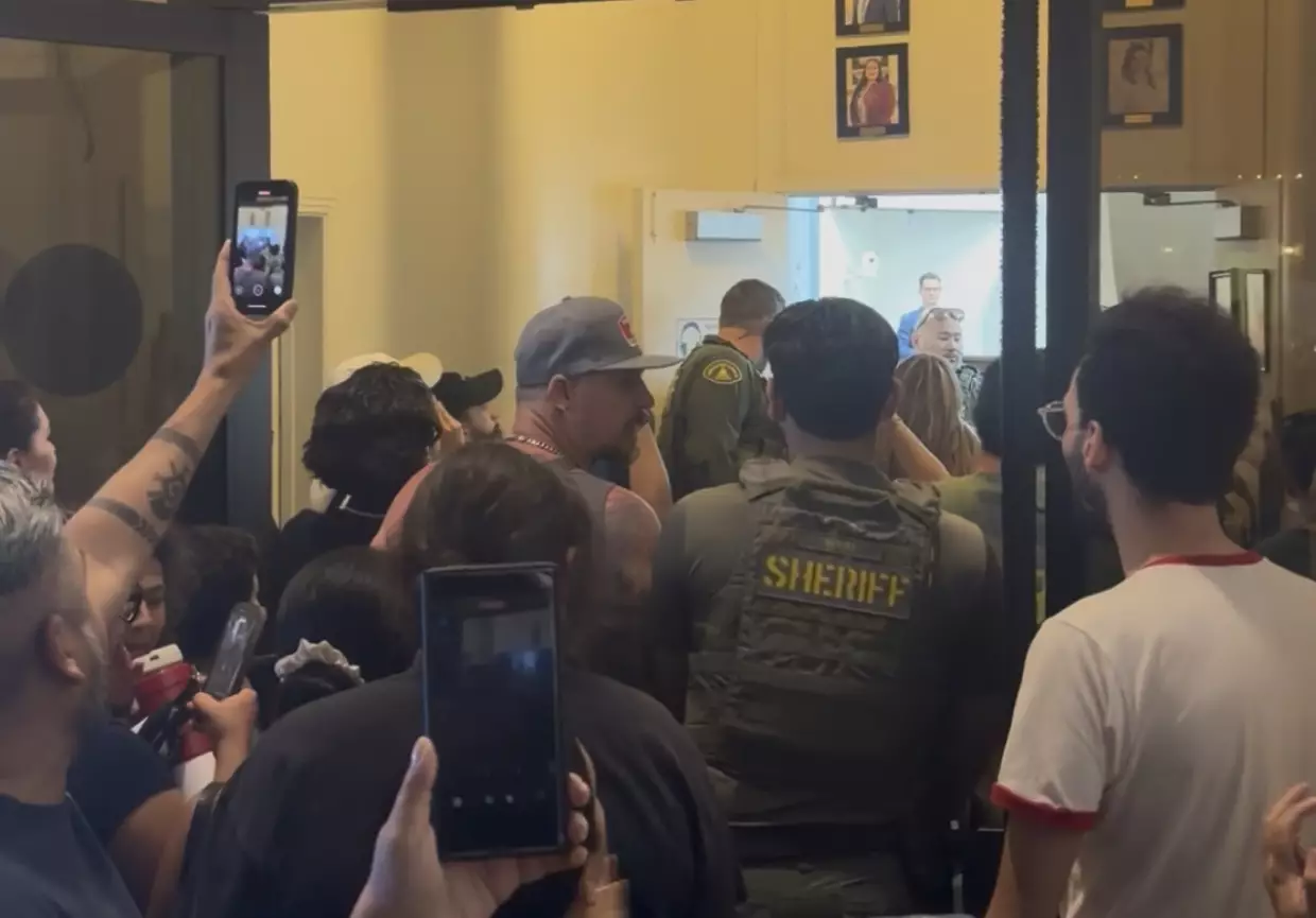 Residents crowd the hallway outside Coachella City Hall during a Wednesday, May 27, 2026 council meeting as tensions flare over a proposed tech campus that would build six data centers on 450 acres.<br>