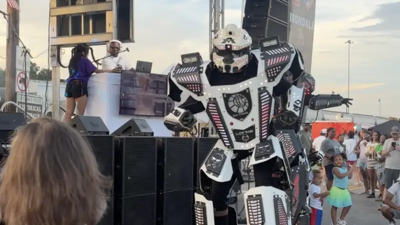 A dancer on stilts dressed as a robot