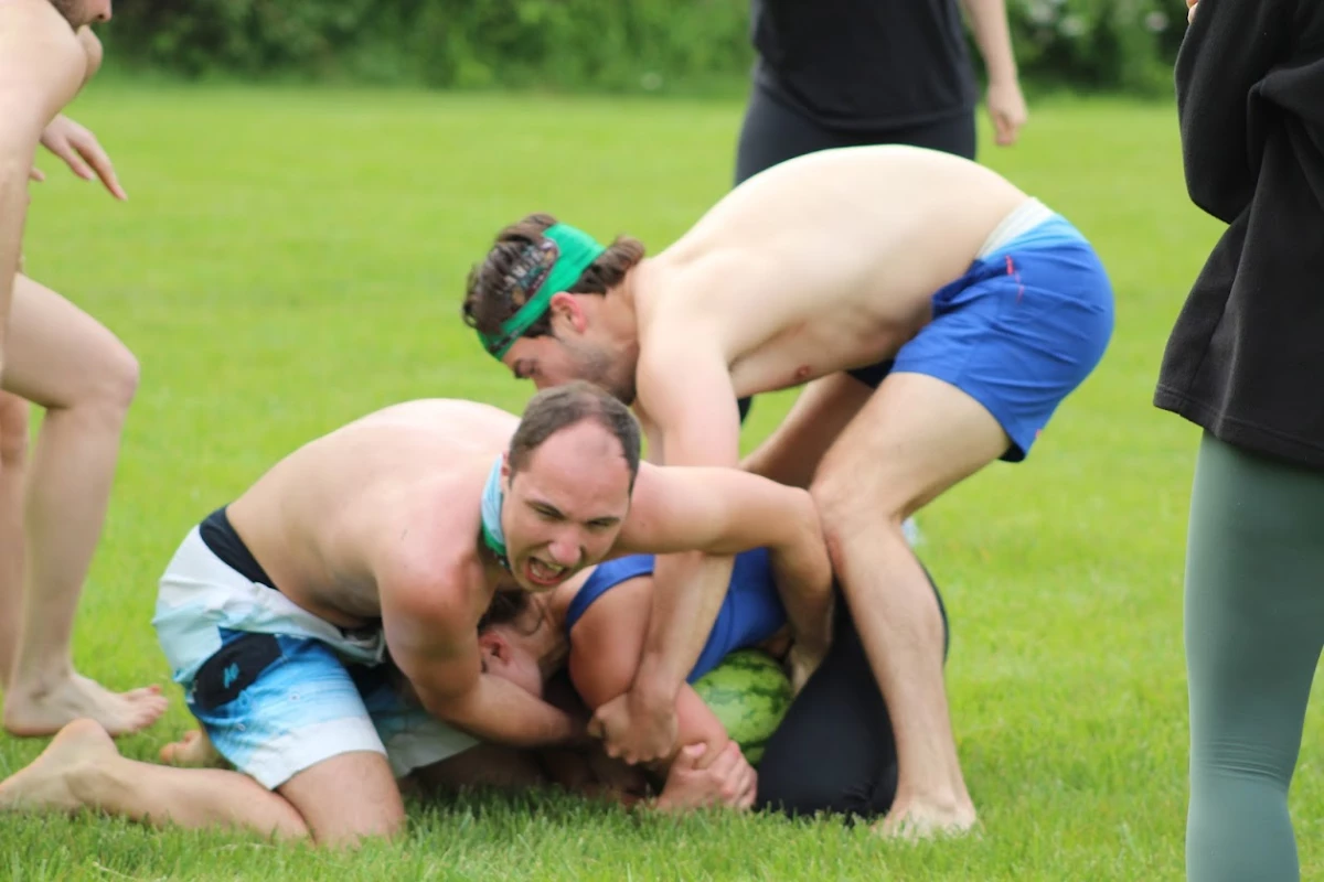 Ian Scaduto (L) and Justin Grant (R) try to wrestle the Crisco-covered watermelon out of Juliana McCormick's death grip. They are not successful.