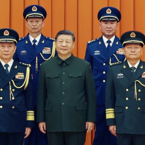 In this photo released by Xinhua News Agency, Chinese President Xi Jinping, also chairman of the Central Military Commission (CMC), front row second from left, poses with other military officers after promoting to generals, back row, from left, Yang Zhibin of the Eastern Theater Command and Han Shengyan commander of Central Theater Command in Beijing on Monday, Dec. 22, 2025.