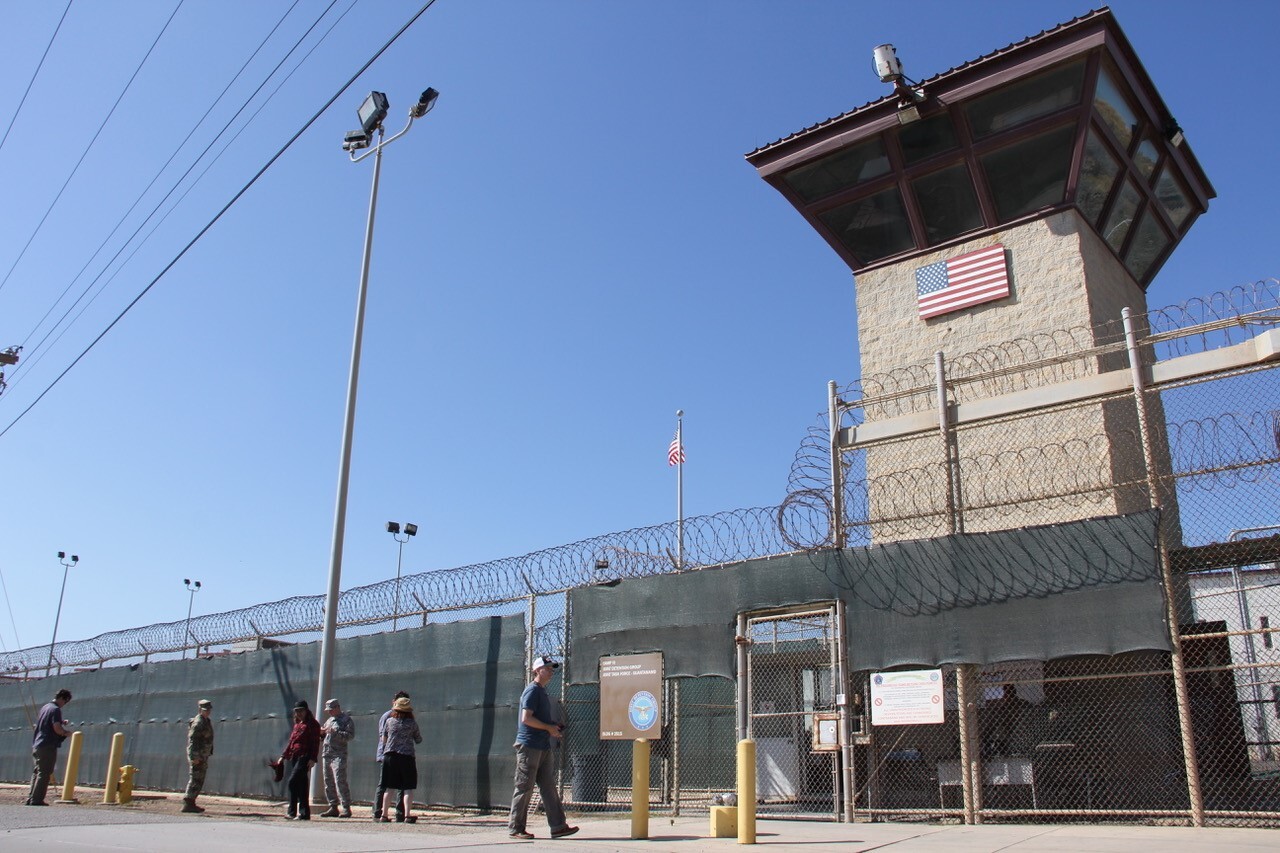 People walk past a guard tower outside the fencing of Camp 5 at the the U.S. military's prison in Guantánamo Bay, Cuba, on Jan. 26, 2017. (AFP via Getty Images)