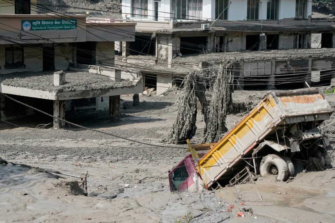 Damaged houses and vehicles are seen in the aftermath of flash floods along the Trishuli River in Nepal's Nuwakot district, Wednesday, Aug. 26, 2026.