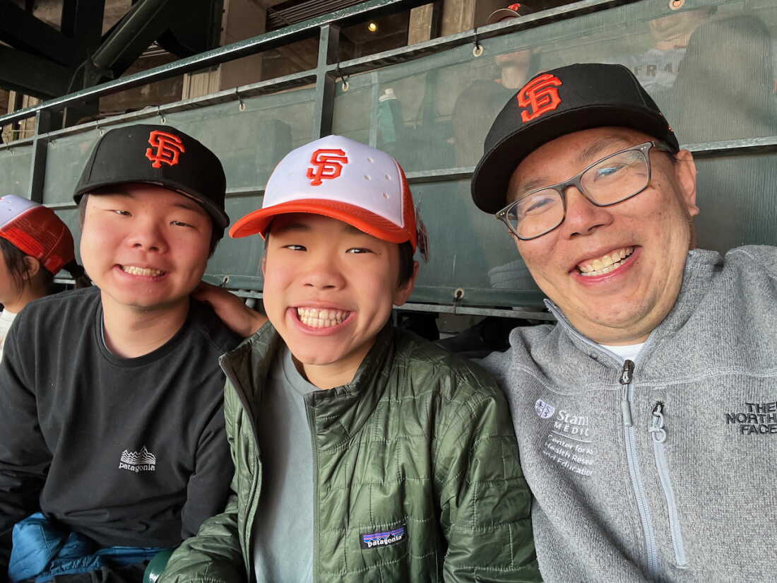 Bryant Lin with his sons at a San Francisco Giants baseball game in spring 2025. He says he loved going to Giants games with his sons before getting diagnosed. "Fortunately, we have been able to go again as a family in 2025 and 2026," he says.