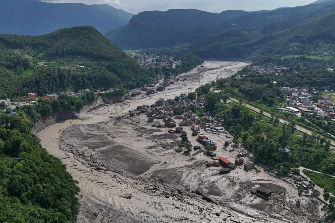 Damaged houses stand precariously near the swollen, debris-choked banks of the Trishuli River after flash floods in Nepal's Nuwakot district on Wednesday.