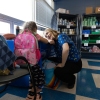 Megan Mainzer, the McKinney-Vento liaison for Middletown Public Schools in Rhode Island, speaks with a young girl at a school food and clothing pantry that's managed, in part, with federal grant money.
