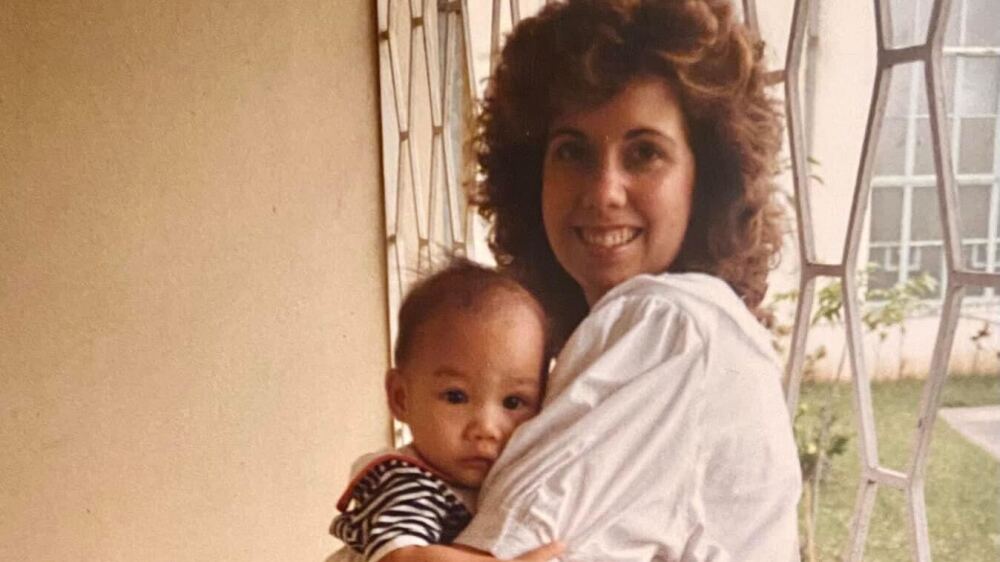 A 10-month-old Ashley Westerman is held by her mother for the first time at the Heart of Mary Villa orphanage in Manila, Philippines, in 1988. (NPR)