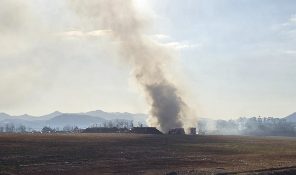 Firefighters work to extinguish a fire off the runway of Muan International Airport in Muan, South Korea, Sunday.