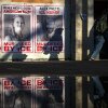 People walk by signs showing the faces of Renee Good and Alex Pretti, the two U.S. citizens killed by federal immigration agents during the ICE surge in Minneapolis.