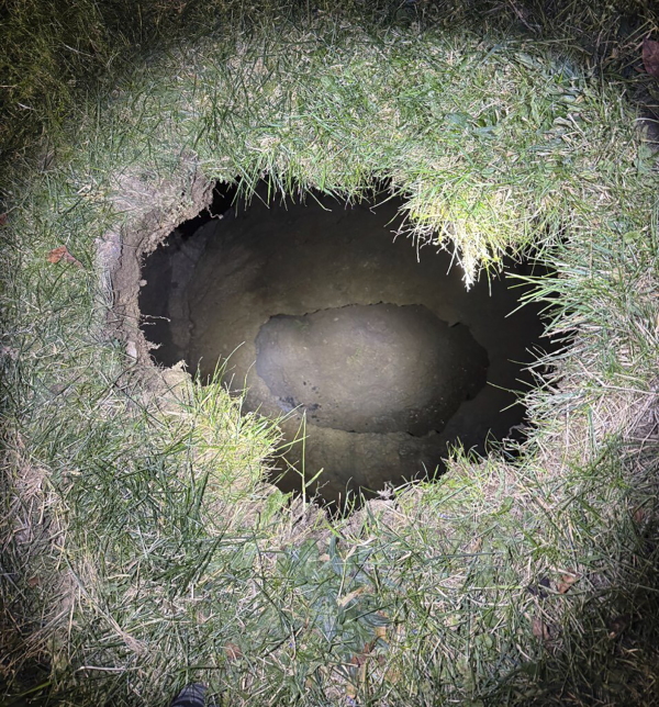 This Tuesday image provided by the Pennsylvania State Police shows the top of a sinkhole in the village of Marguerite, Pa., where rescuers were searching for a woman who disappeared.