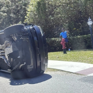 Golfer Tiger Woods stands by his overturned vehicle in Jupiter Island, Fla., on Friday, March 27, 2026.