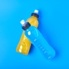 Orange and blue sports drink in plastic bottles on a blue background.