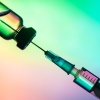 vaccination syringe and bottle on a colored background. close up, copy space