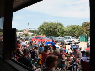 Customers sit in lawn chairs waiting for Goldee's BBQ to open on a summer Saturday in Fort Worth, Texas.