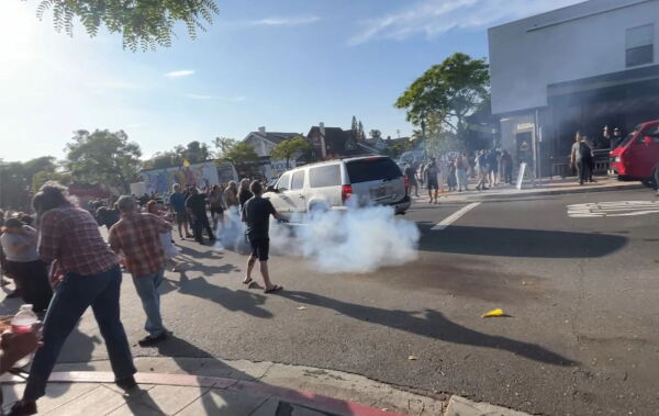 ICE agents use a smoke device to disperse a crowd in San Diego, Calif., on May ⁢30,⁣ 2025.