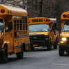 In this photo, three yellow school buses idle in a street in Manhattan's East Village on January 15, 2013.