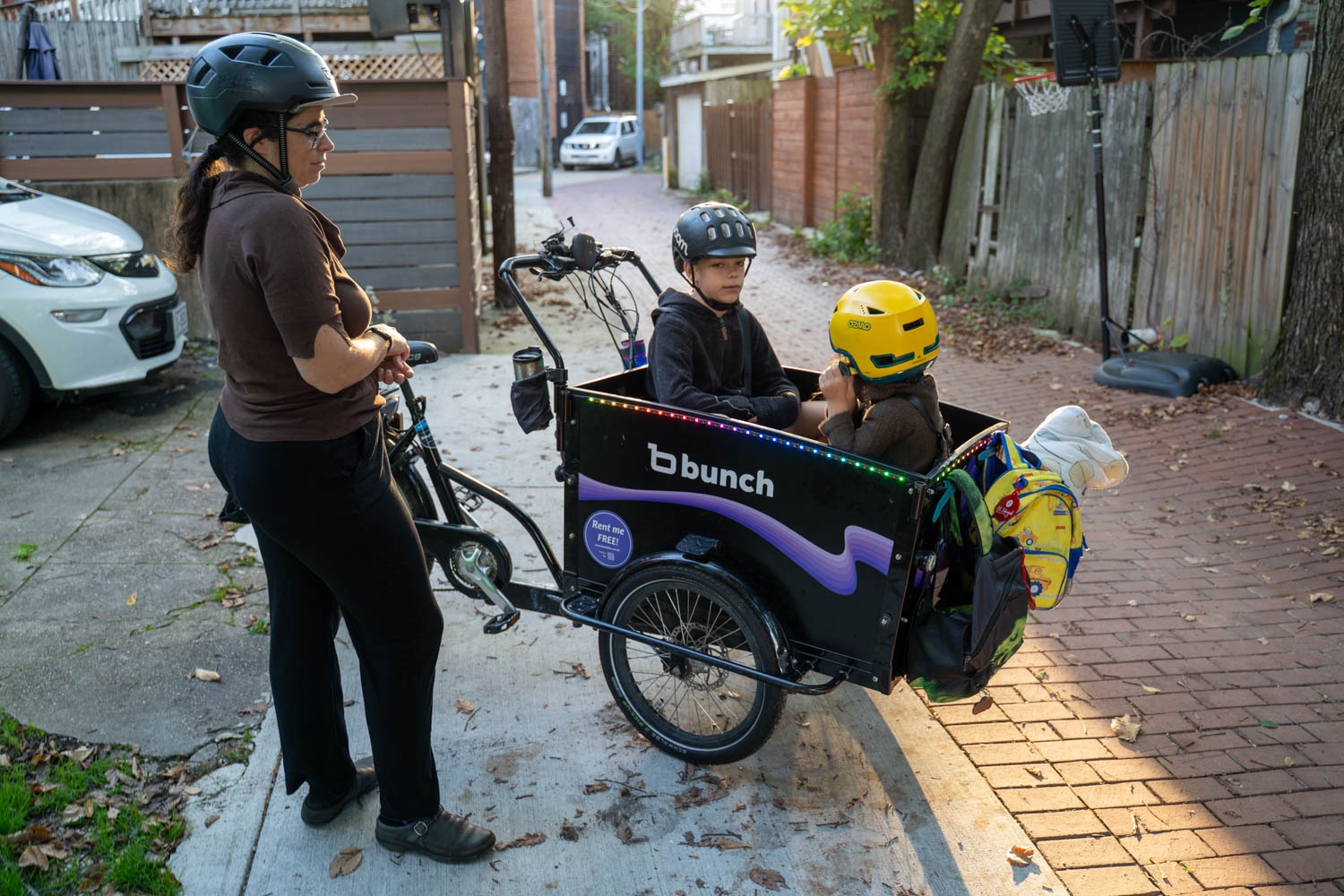 Lelac Almagor waits as her kids get ready for the ride to school. Her cargo bike is technically a trike, with two wheels in front for more stability.