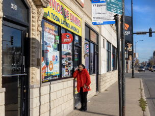 Nelly Villanueva calls her mother in Mexico outside a money order business in Chicago in 2021.