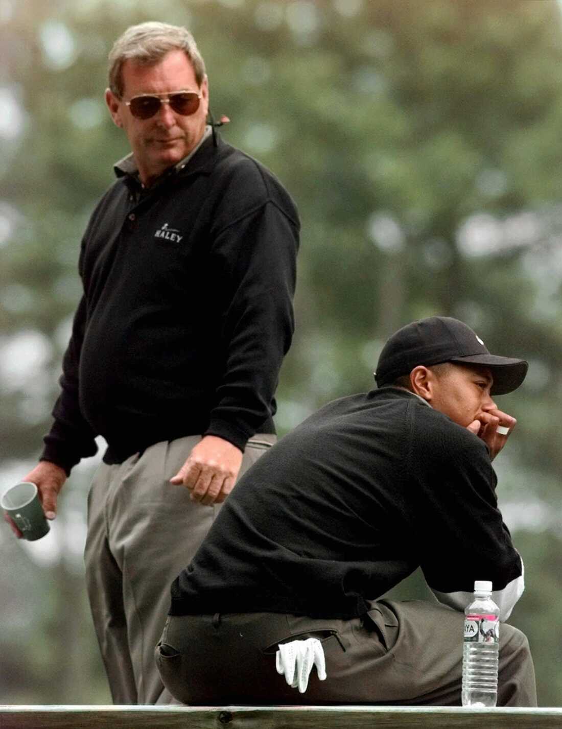 In this Friday, April 10. 1998 file photo, Fuzzy Zoeller looks back at defending Masters champion Tiger Woods, right, while they both wait their turns to tee off from the fourth hole during the second round of the 1998 Masters in Augusta, Ga. In 1997, Zoeller joked that Woods shouldn't order fried chicken for the next year's Masters champions' dinner. He said the comments were 