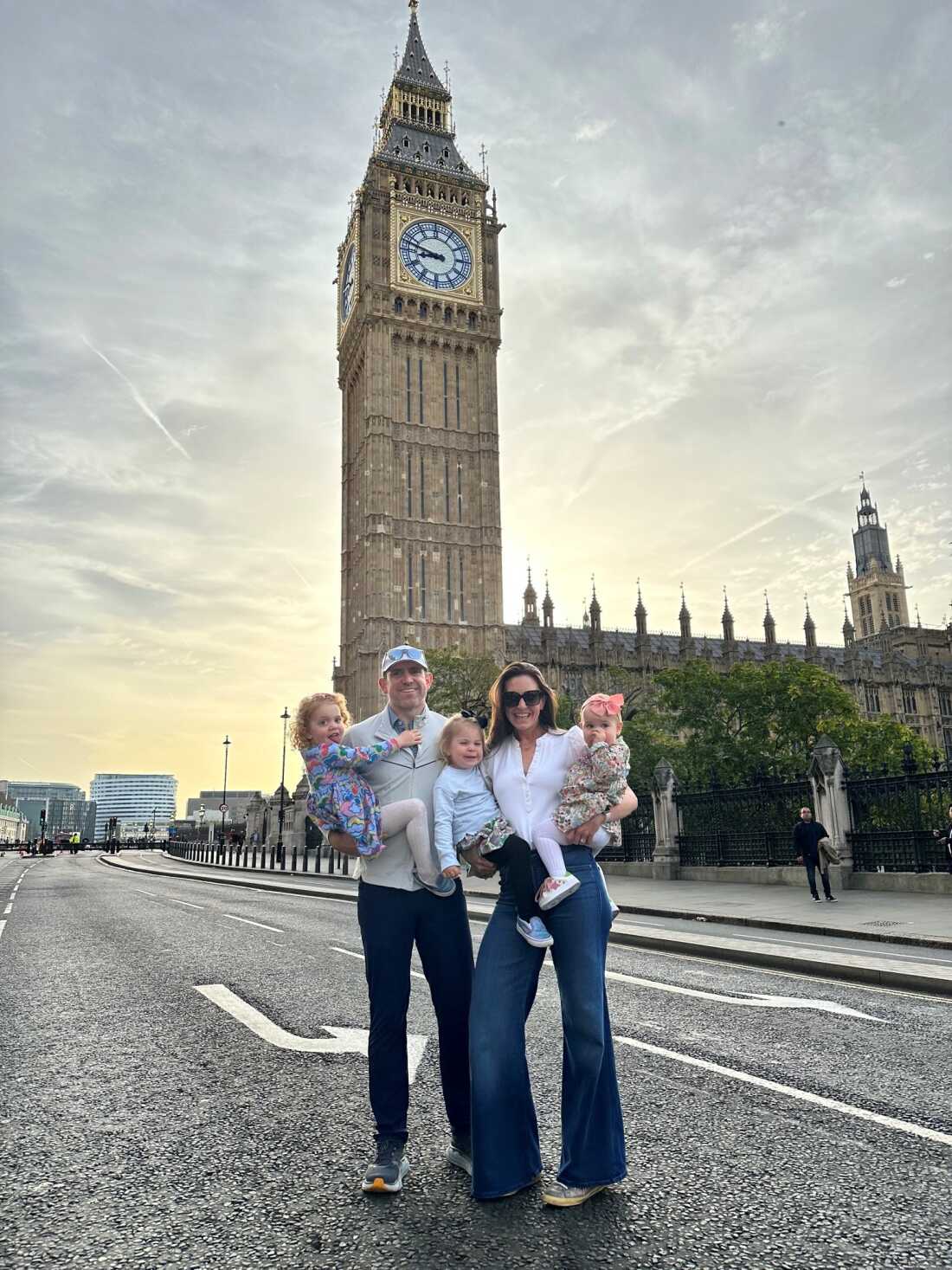 Maggie Loucks and her husband hold their three toddler daughters standing in front of the Big Ben, the London landmark.