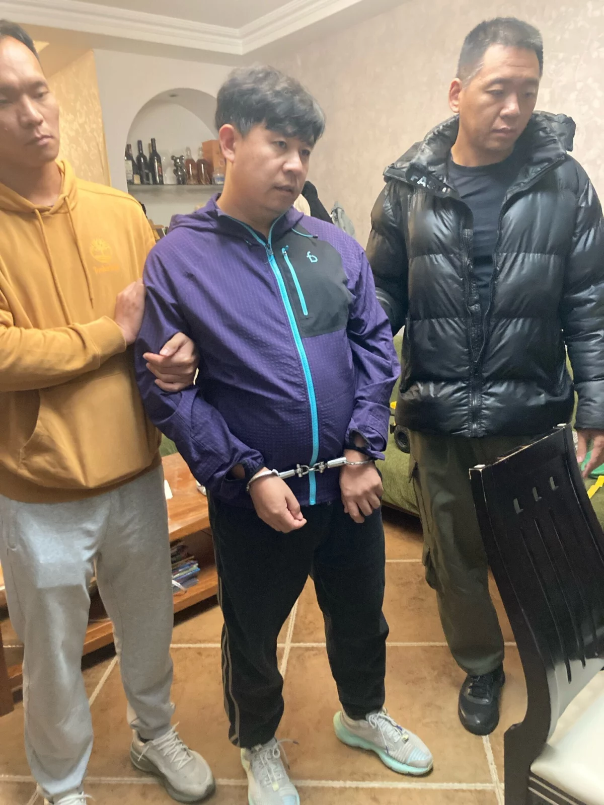 This photograph provided by pastor Sean Long of Zion Church shows shows pastor Sun Cong of Zion Church standing, wearing handcuffs, after being detained by police at his home in Beijing, China, on Friday.