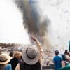 Wyoming, USA - A crowd of people witness the rare eruption of Steamboat Geyser, which can rise hundreds of feet into the air.