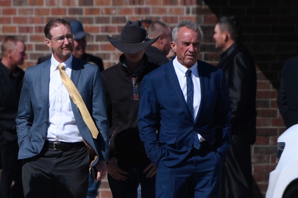 Health and Human Services Secretary Robert F. Kennedy Jr., right, arrives at Reinlander Mennonite Church after a second measles death of a child, on Sunday in Seminole, Texas.