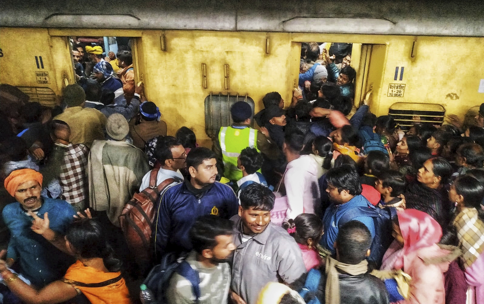 Passengers jostle with each other to board a train at the New Delhi Railway station, in New Delhi, India, Saturday, Feb.15, 2025.