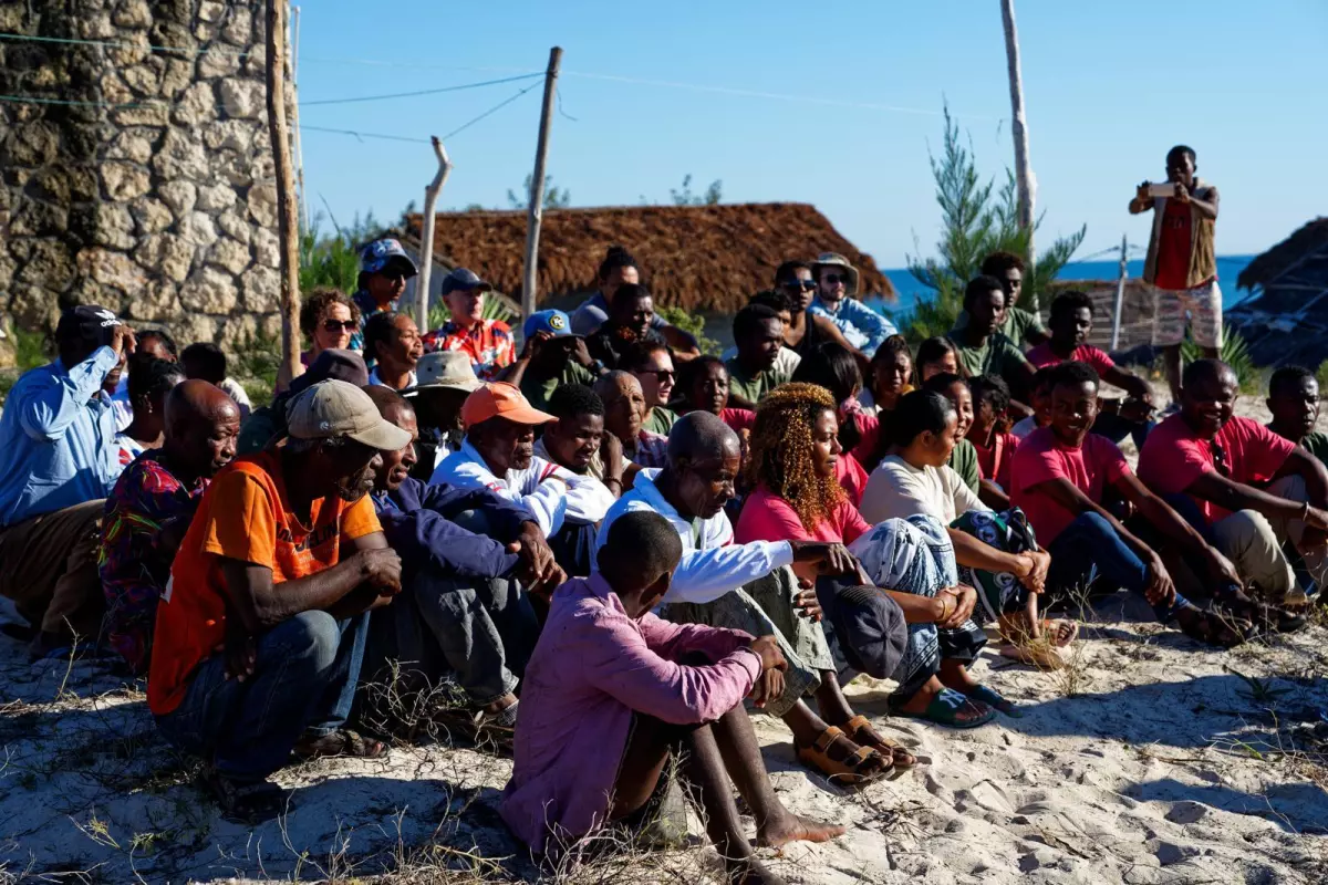 Kristina Douglass (first row, in red blouse) sits with her Malagasy collaborators in southwest Madagascar, participating in a ceremony that seeks ancestral blessings for their research.