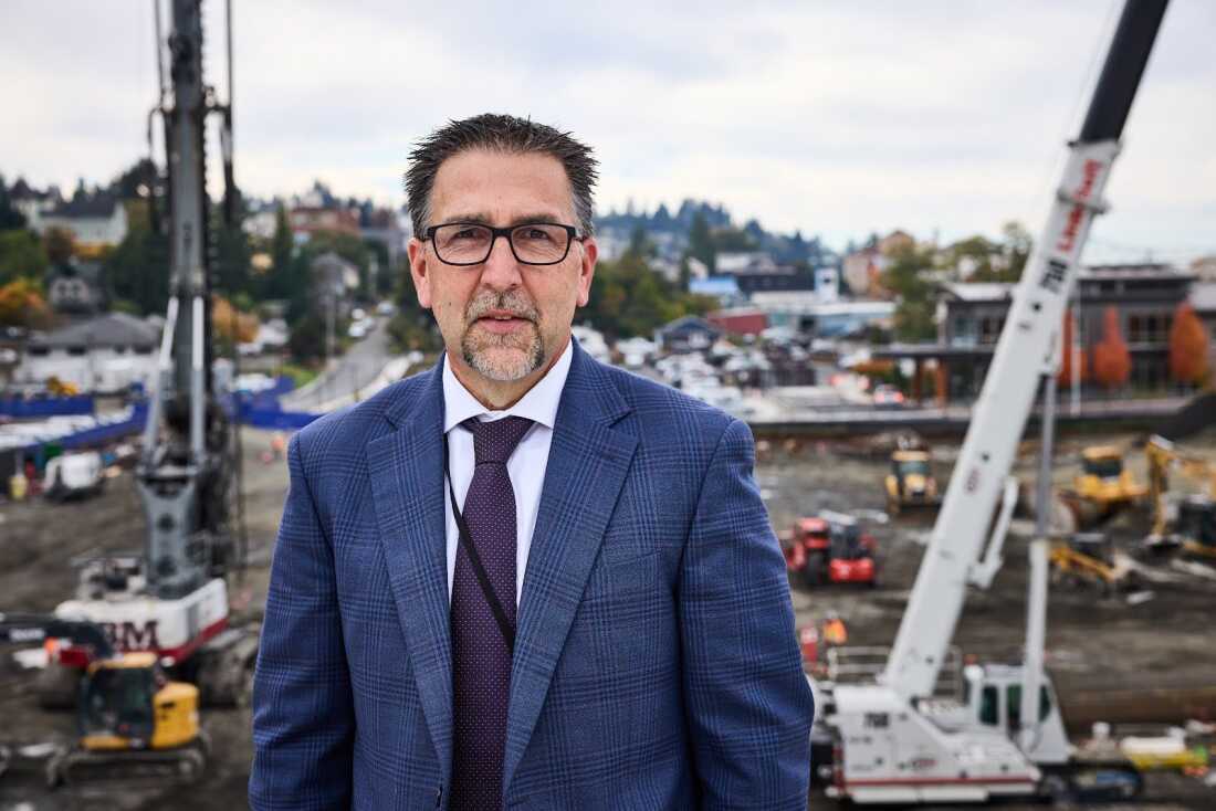 Erik Thorsen, CEO of Columbia Memorial Hospital in Astoria, Ore., stands on the hospital roof overlooking the construction. The project, designed to fortify the building in the event of an earthquake and provide shelter during a tsunami, is proceeding — even without funds promised from the federal government.