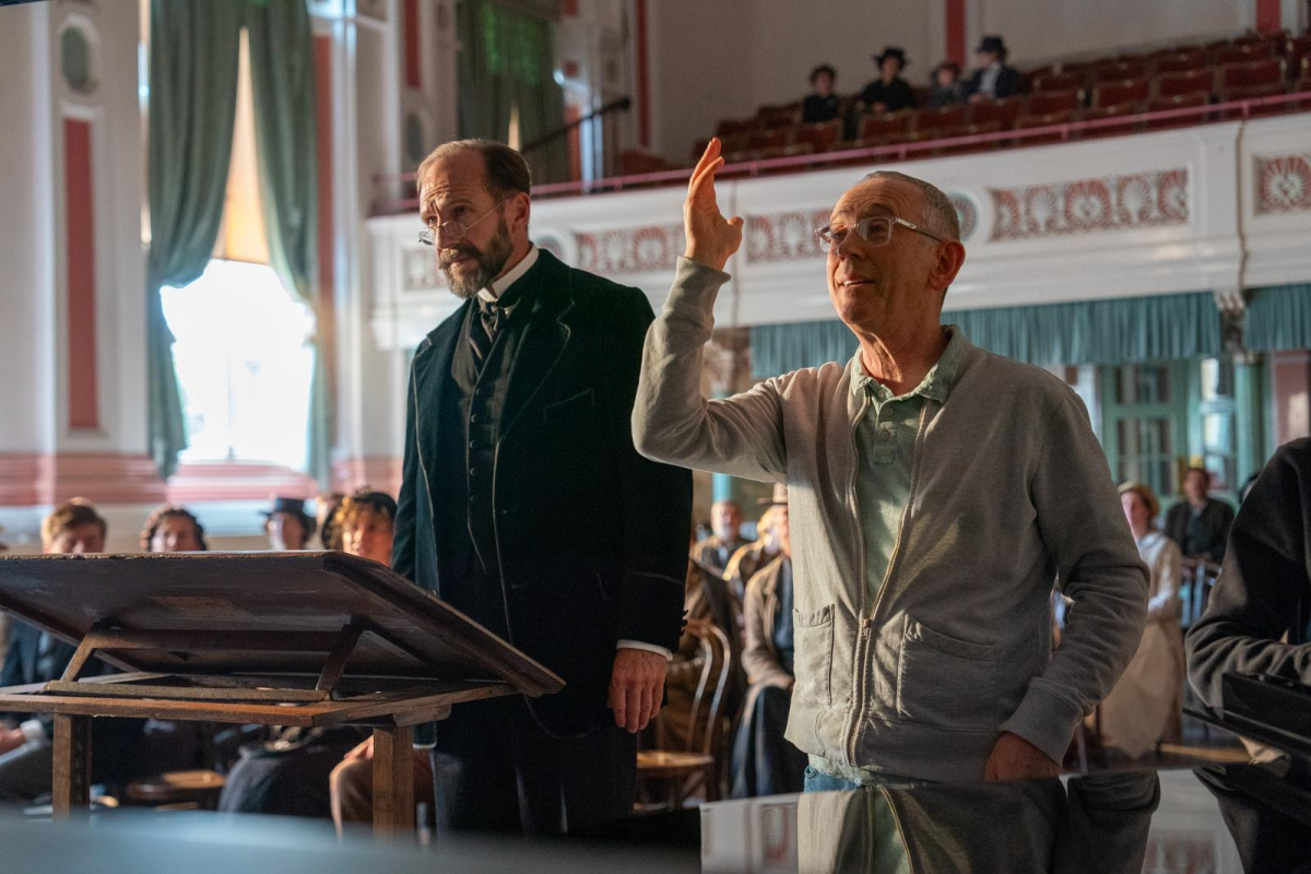 Director Nicholas Hytner, right, gestures on the set of The Choral with Fiennes, left, by his side.