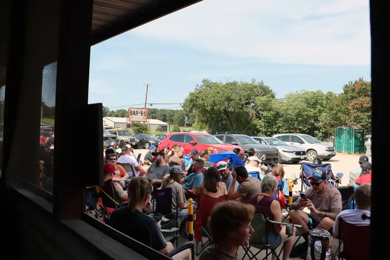 Customers sit in lawn chairs waiting for Goldee’s BBQ to open on a summer Saturday in Fort Worth, Texas. (RNS photo/Fiona André)