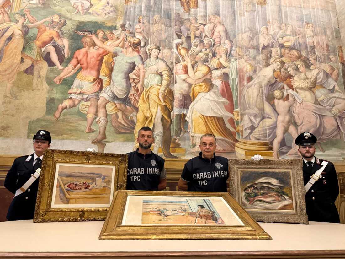 In this picture made available by the Italian Carabinieri in Parma, northern Italy, Friday, Aug. 14, 2026, Carabinieri pose near three artworks recovered following a police operation.