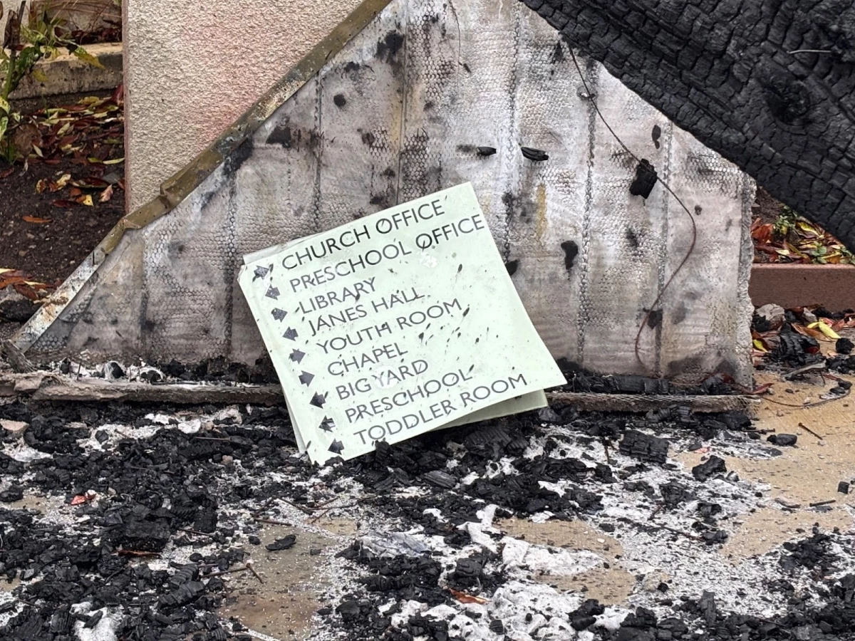 A sign at Palisades Presbyterian Church sits among the charred remains of the buildings.