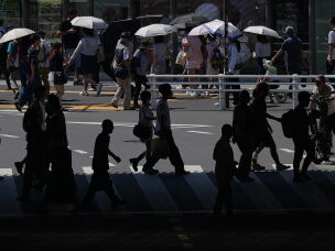 People walk across a pedestrian crossing under the scorching sun on Tuesday, Aug. 25, 2026, in Tokyo.