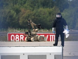 A forensic technician works alongside a bomb-disposal robot near a Ukrainian aircraft at Leipzig/Halle Airport, where a drone with an explosive device was found and a detonator was removed from the object, in Schkeuditz, Germany, Wednesday Aug. 5, 2026.