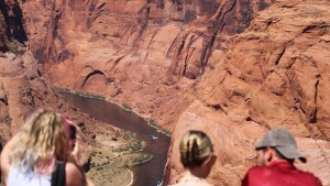 Tourists look out at the Colorado River at Horseshoe Bend in Page, Arizona on May 14, 2026. Water supplies are shrinking due to climate change and drought, and the new plan is an attempt to rein in demand.