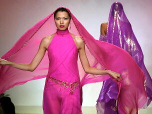 An example of Bob Mackie's work in haute couture: A model presents a hot pink chiffon gown with jeweled hip belt at Mackie's show during Fall 2001 Fashion Week in New York.