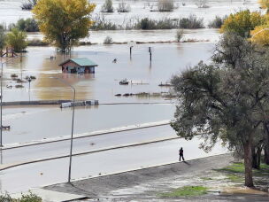 A person walks along the edge of a flooded road in Shiprock, New Mexico.