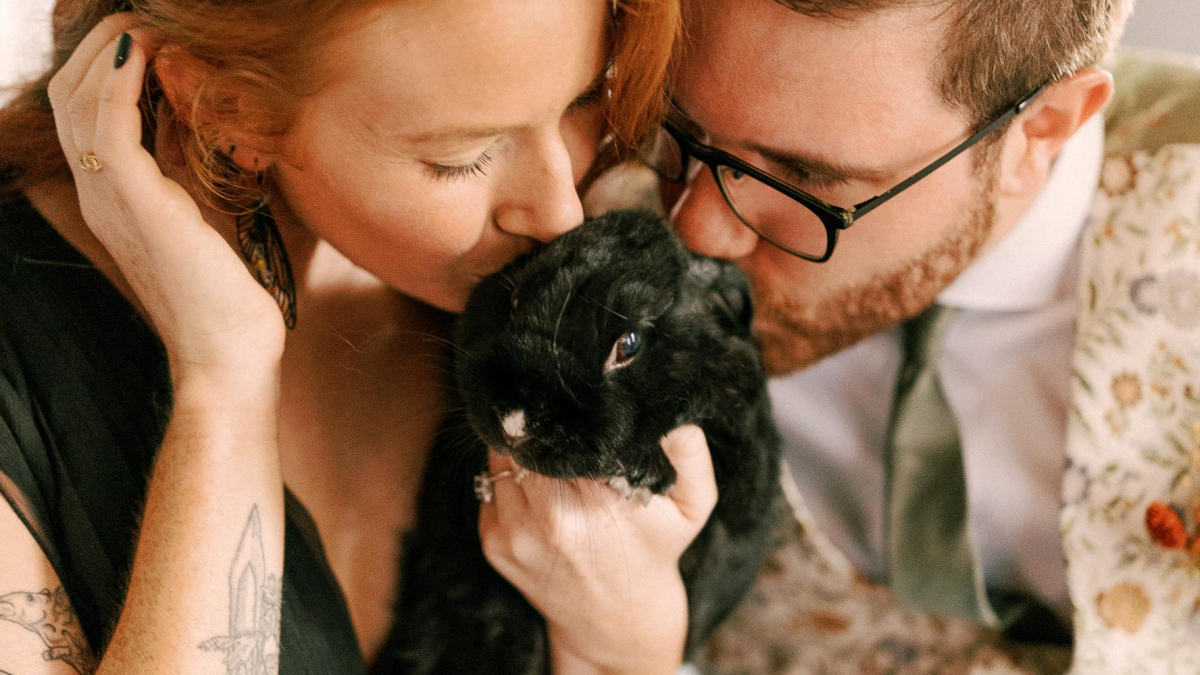 Olivia Poelmann and her husband kiss their rabbit Sirius.