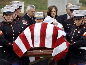 CIA officer Johnny Michael Spann, 32, was the first American killed in Afghanistan after the Sept. 11, 2001, attacks in the U.S. Spann's widow, Shannon Spann, and their 6-month-old son Jake follow Spann's casket to the grave site at Arlington National Cemetery on Dec. 10, 2001. The CIA's paramilitary force grew substantially as the agency joined the fight in Afghanistan after the 9/11 attacks.